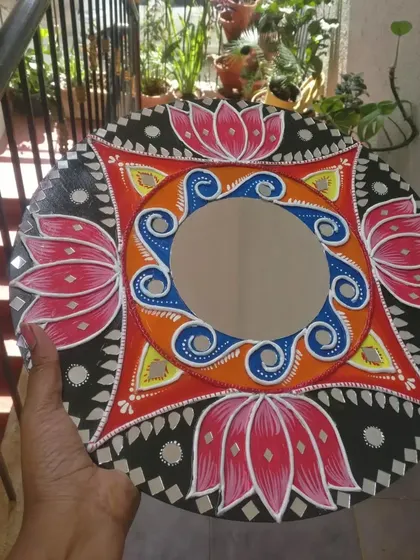 A different angle of the lotus-themed Lippan art mirror, showing how it looks in natural light.