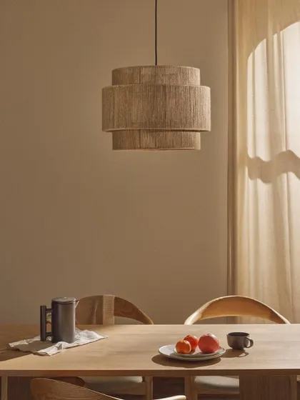 A tiered pendant light wrapped in natural jute fiber. This fixture is perfect for adding a touch of bohemian or coastal style to a dining area.