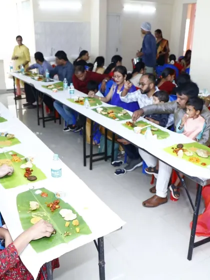 A view of guests dining at long tables, fully immersed in the traditional 'ele oota' experience.