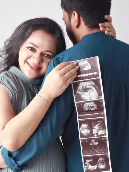 Sharing a secret with the world. This playful pose with the ultrasound strip is a creative way to announce your pregnancy and celebrate this special milestone together.