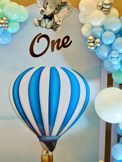 A close-up of the hot air balloon backdrop from Aarush's party, showing the mix of blue, mint, and silver balloons.