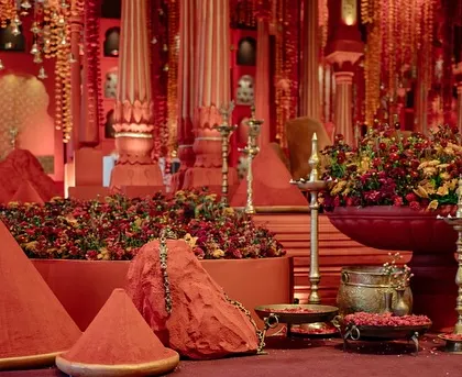 Heaps of sindoor and vibrant red and orange flowers create a powerful visual statement, embodying the 'Lal Bagh' theme of strength and tradition.