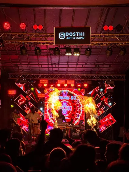 The crowd's view of the show, with fire performers adding to the spectacle of the DJ and Chenda fusion.