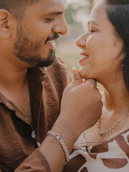 A tender close-up from an outdoor shoot. The groom gently holding the bride's chin creates a very intimate and affectionate moment between them.