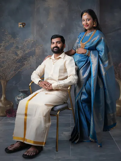 A formal portrait of the couple in traditional South Indian attire. The dad-to-be is seated, creating a classic and respectful pose that honors their heritage.