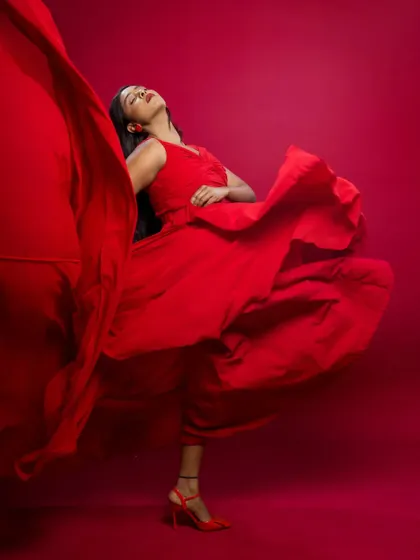 The red dress in full flight. This shot captures the fabric in motion, creating a sense of freedom and high-fashion energy.