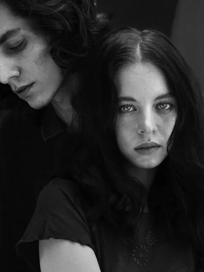 A black and white version of a couples portrait, emphasizing the emotional distance and connection through stark contrast and composition.