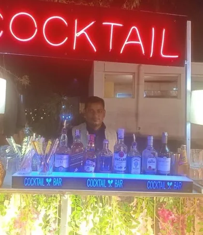 A classic cocktail bar setup with a bright red neon sign, perfect for any celebration.
