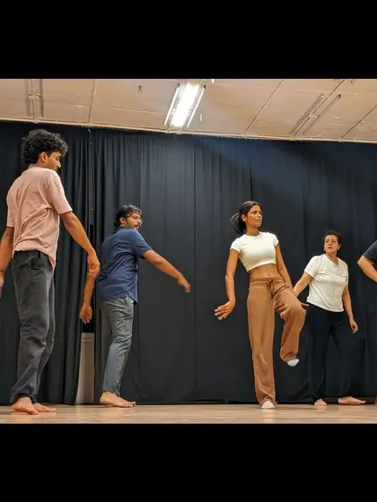 Students work together to understand a piece of choreography, fostering a collaborative learning environment.