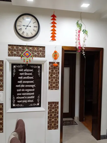 This decoration was designed around the family's Navkar Mantra frame. I added simple, colorful hangings to complement the existing spiritual decor in the home.
