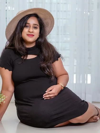 A direct and engaging portrait of the mother-to-be. Her simple black dress and hat create a chic and effortless look.
