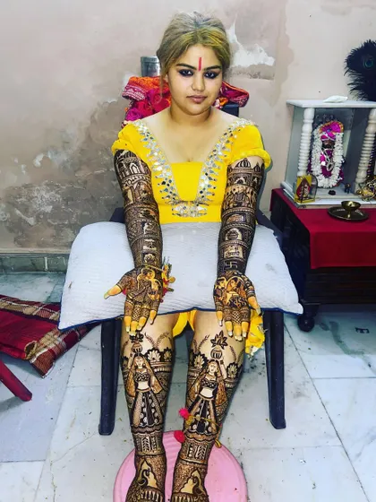 A full bridal look, with intricate mehndi covering the hands, arms, and legs up to the knees. This is the ultimate in bridal henna adornment.