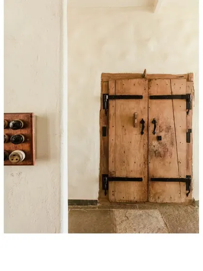 This old door with heavy iron hardware was salvaged and given a new life. It adds an authentic, old-world charm to the space.