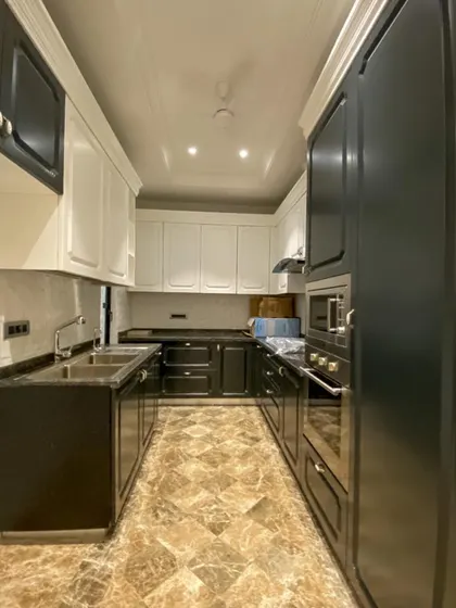 This kitchen at C-926 combines dark and light cabinets for a dramatic, modern look. The Italian marble flooring and under-cabinet lighting add to the luxurious feel.
