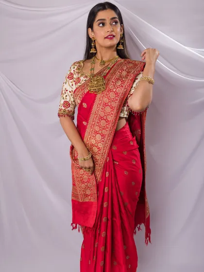 A classic look for a jewellery shoot featuring a stunning red saree. The makeup is timeless with a defined eye and a bold lip, complementing the antique gold jewellery.