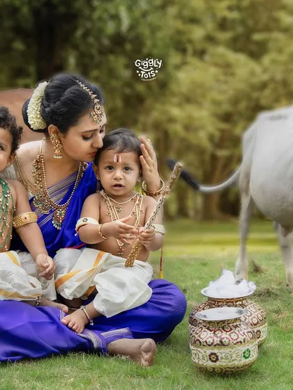 A tender moment as a mother kisses her little Krishna's head, surrounded by the peaceful presence of cows in our outdoor-style setup.