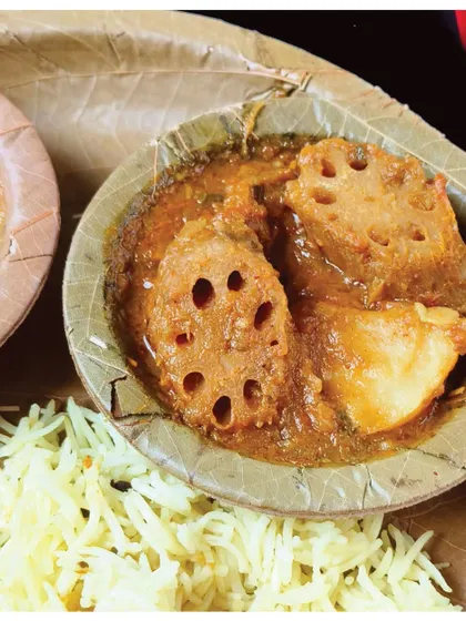 A close-up of the Beeh Patata (Lotus Stem and Potato Curry), a mandatory pre-wedding meal in Sindhi culture until the 1970s.