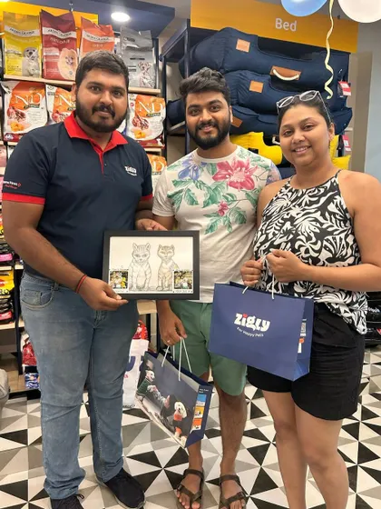 A customer and our staff member holding a framed caricature, showing the fun and personal touches we add to our community events.