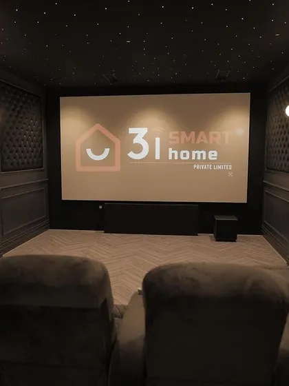 The view from the back row, showing my company logo on the massive 165-inch screen. The starlit ceiling and herringbone floor complete the premium look.