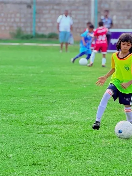 A young female player dribbling the ball during a KSFA Youth League game. We encourage and support girls to compete at the highest level.
