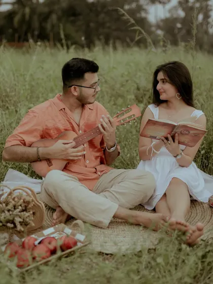 A beautiful shot of the couple looking at each other while he plays the guitar.