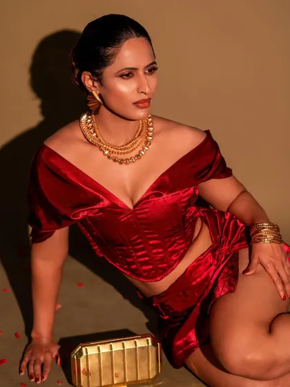 A fashion-forward portrait featuring a red velvet outfit and layered gold necklaces. This shot is all about attitude and modern style.