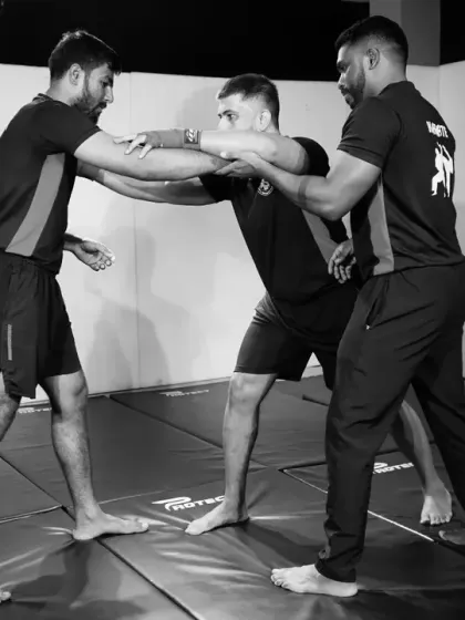 An instructor works with two students on clinch-fighting and control techniques. Learning to manage the close-range struggle is a key aspect of our practical self-defense curriculum.