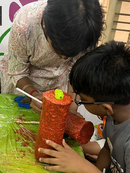A close-up of a student carefully painting his rain stick. This project requires focus and a steady hand, and the results are both visually and audibly rewarding.