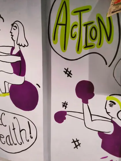 A close-up of the gym mural, showing doodles of a woman on an exercise ball and another boxing, with the word "Action" in a speech bubble.