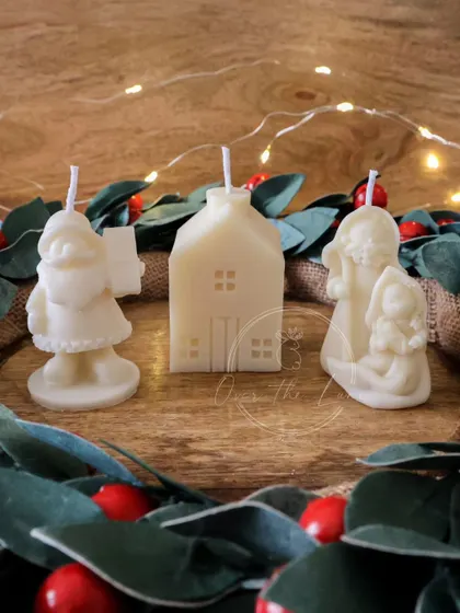A sweet trio of Christmas character candles, including a snowman, a house, and an angel.