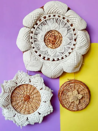 Here you can see a collection of my wicker and macrame wall art. I enjoy mixing materials to create unique textures, like the combination of woven cane with detailed cotton knot work.