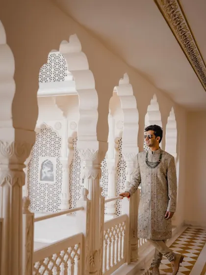 The groom looking sharp against the intricate jali work of the Anantara Jaipur, a perfect example of a royal groom portrait.