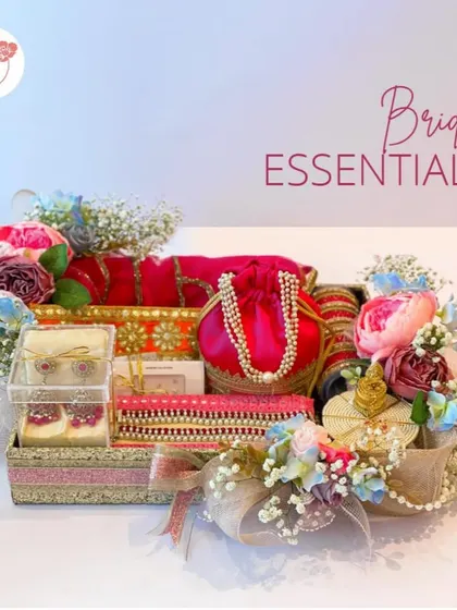 A full view of the "Bridal Essentials" hamper, a vibrant collection of traditional pouches, jewelry, and other accessories in bright pinks and oranges.