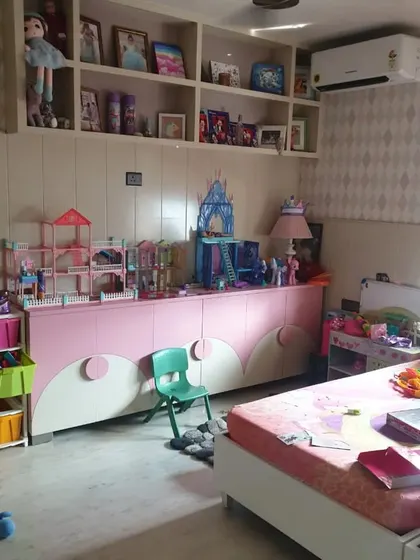 We also design spaces for the younger members of the family, like this playful and organized kids' room with custom pink storage units and open shelving.
