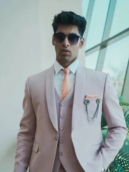 A model wearing our stylish pastel pink three-piece suit. It's a contemporary and confident choice for any celebration.
