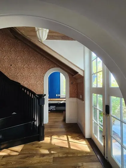 A work-in-progress shot of the entryway in the Saratoga home. You can see the vision starting to take shape, with the newly painted black staircase, the beautiful archways, and the light streaming in through the front doors.