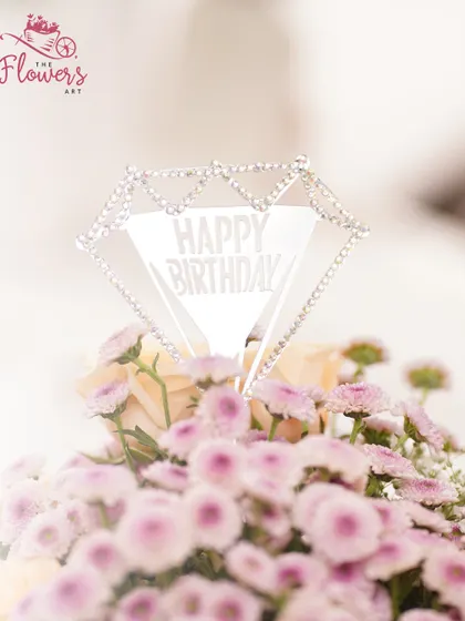 A close-up of the elegant 'Happy Birthday' topper, which adds a celebratory and personal touch to the floral gift. It's these small details that make a gift feel truly special.