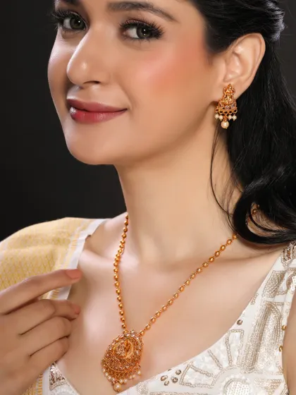 A close-up shot of a model wearing a delicate gold necklace with pearl accents, suitable for a subtle and elegant collection.