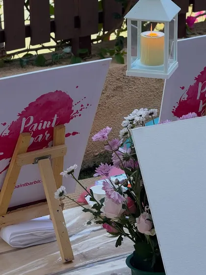 A close-up of our personalized setup, including branded canvases and beautiful floral arrangements. We believe in making every event special.