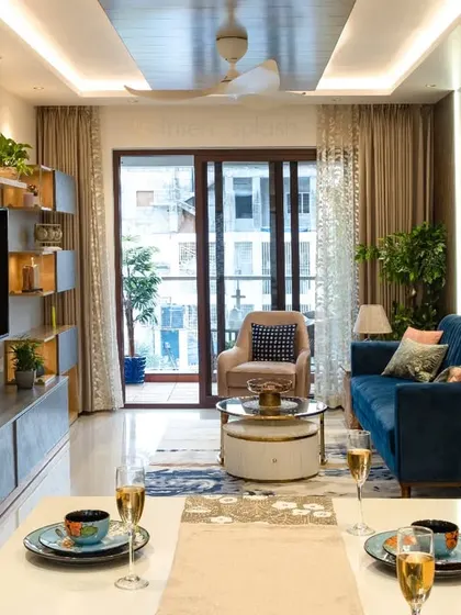 A complete view of a living and dining area. The design uses a consistent color palette and lighting to create a harmonious flow from the dining table to the sofa and TV unit.