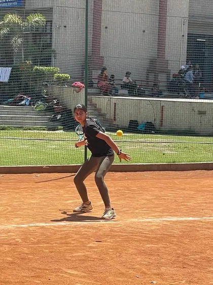 A female player hitting a backhand on the move during an AITA CS-7 tournament. We train our players to be effective even when pulled wide.
