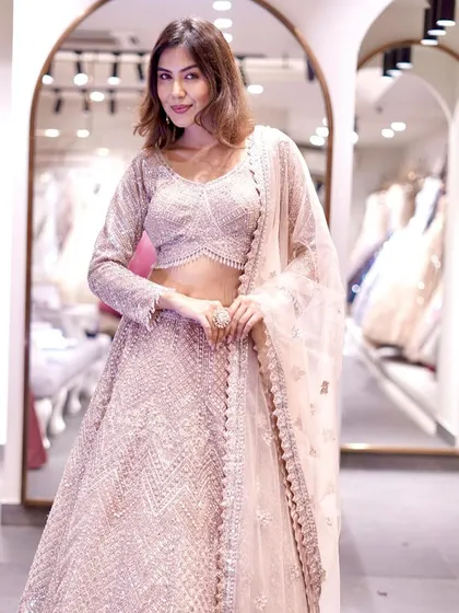 A full shot of the stunning rose gold lehenga. The intricate all-over embroidery and the elegant silhouette make it a truly special piece.