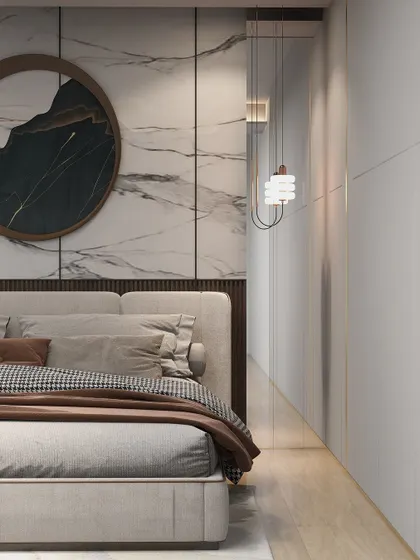 A close-up of a neutral-themed bedroom, where a marble-finish wall panel and a unique circular artwork create a sophisticated backdrop.