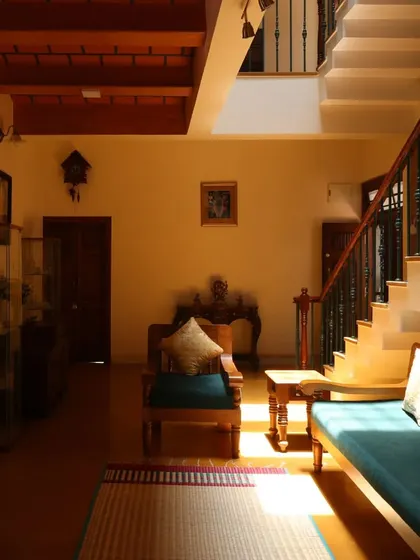 Sunlight falls across the living room floor, highlighting the simple elegance of the wooden furniture and the natural textures of the home.