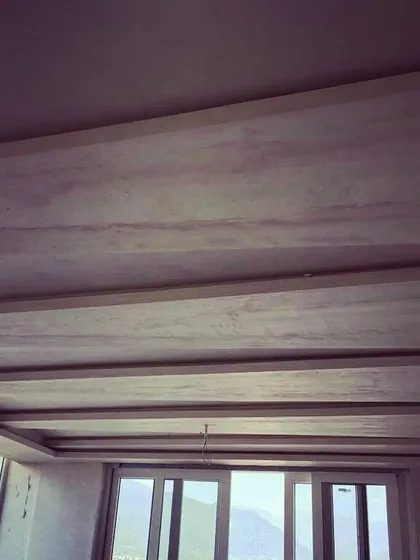 An in-progress shot of a false ceiling installation. This shows the structural framework for a coffered ceiling design before the final plaster and paint are applied, a key element in modern interior design.