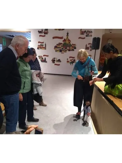 Adults are just as fascinated as children. Here, our team explains the art of puppetry to an engaged group after a show in Germany.
