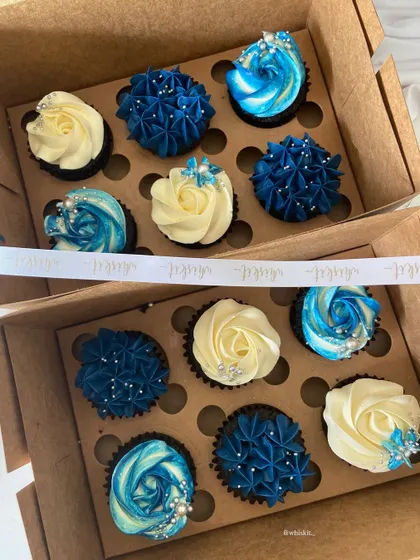 A close-up of the intricate piping on the blue and white cupcakes, showing the detailed craftsmanship in each piece.