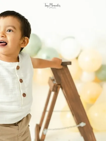 A joyful shout from this little explorer. The boho-themed milestone session with a ladder prop encourages natural play and big expressions.