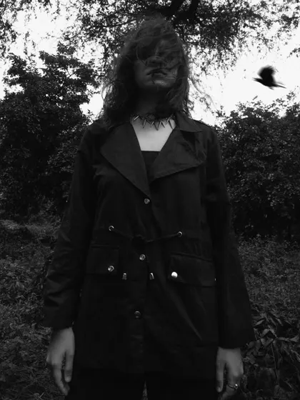 A chaotic and moody black and white shot in a dark, wooded area. The motion blur and the flying bird add to the feeling of wildness.