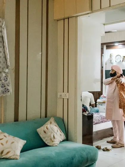 A candid shot of the groom getting ready at home, capturing the authentic, relaxed environment before the wedding festivities kick off.